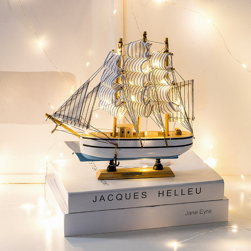 Close-up of Paulownia wood sailboat with white sails