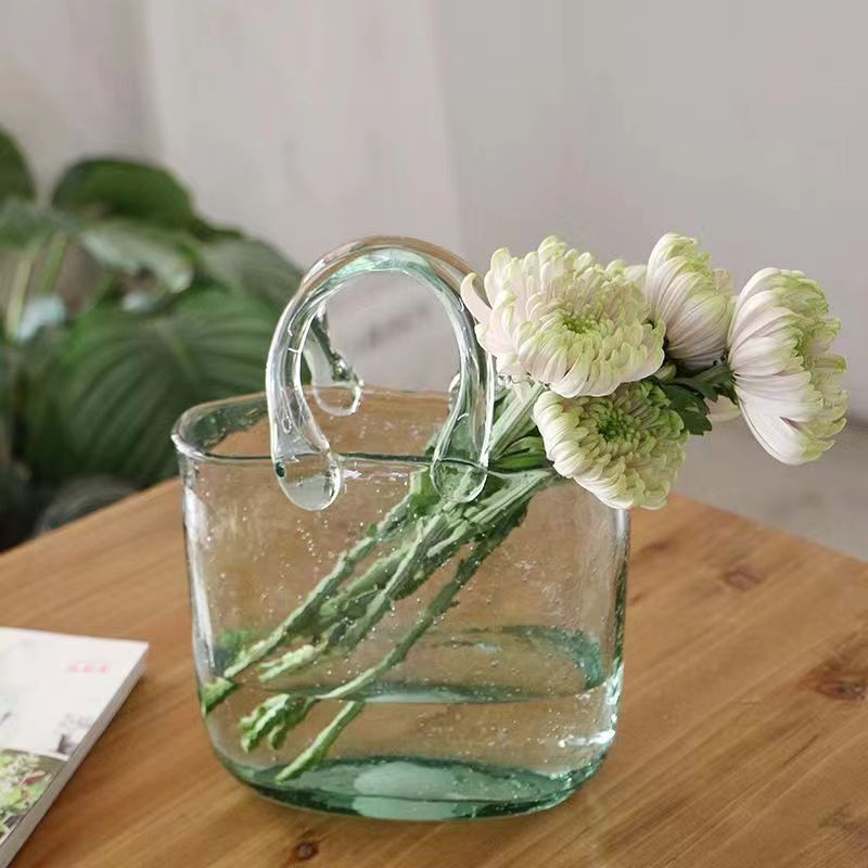 Clear glass handbag vase on white background