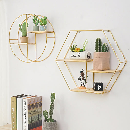 Geometric wrought iron wall shelf in gold finish on white wall
