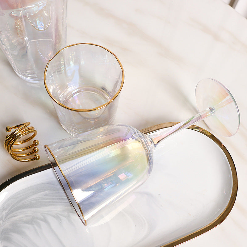 Tall elegant drinking glass with gold trim by window light

