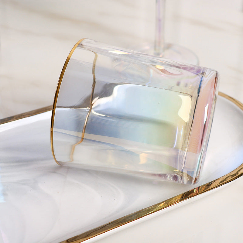 Short gold-rimmed colorful cocktail glass on marble tray
