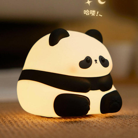 Panda night light next to a child’s bed with soft pillows
