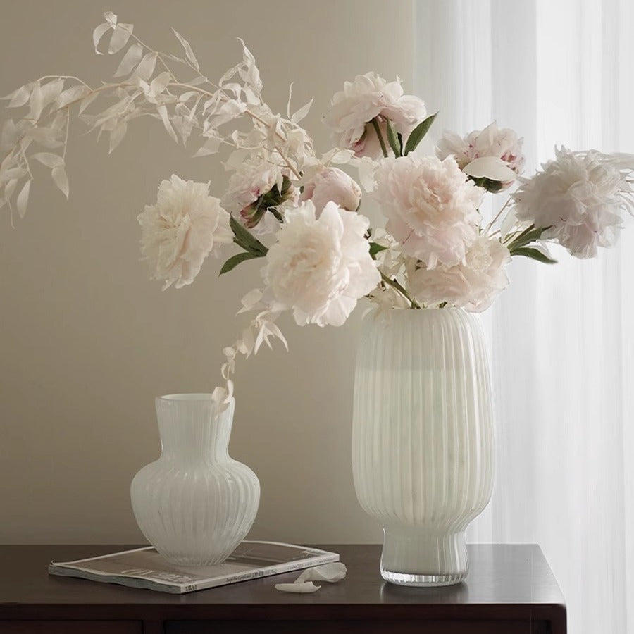 White flow-patterned glass vase on plain background
