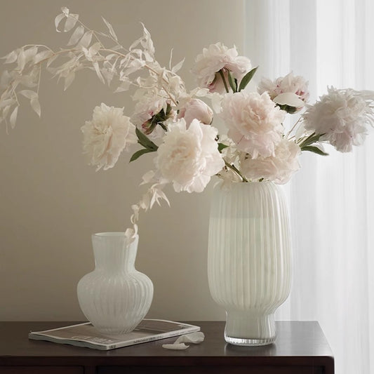 White flow-patterned glass vase on plain background
