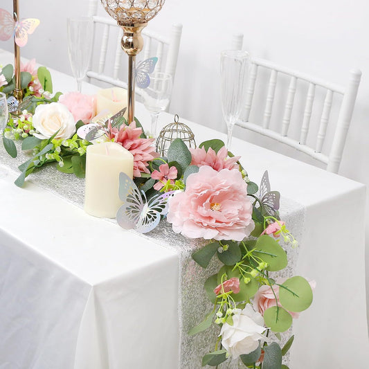 White floral vine decor on a mantle with candles
