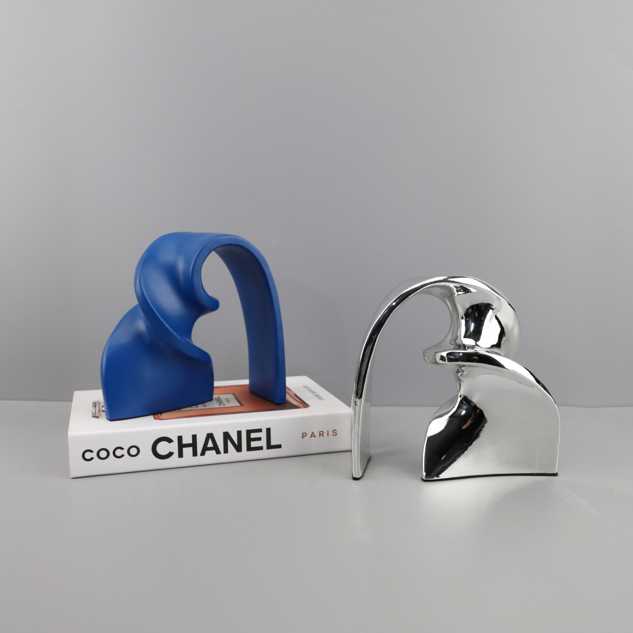 Blue and Silver Nordic arch sculpture on modern console with neutral backdrop
