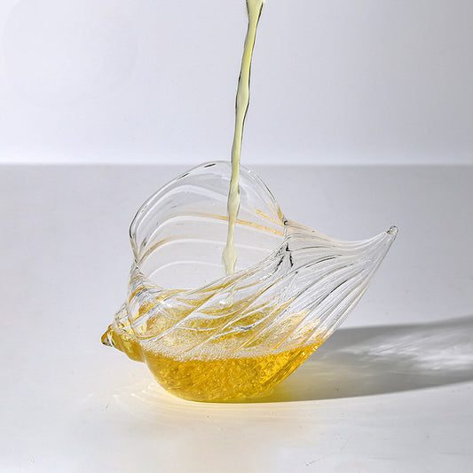 Ocean-inspired striped glass with fluid conch shell curves

