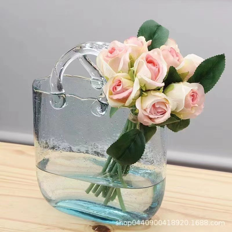 Clear glass handbag vase on white background
