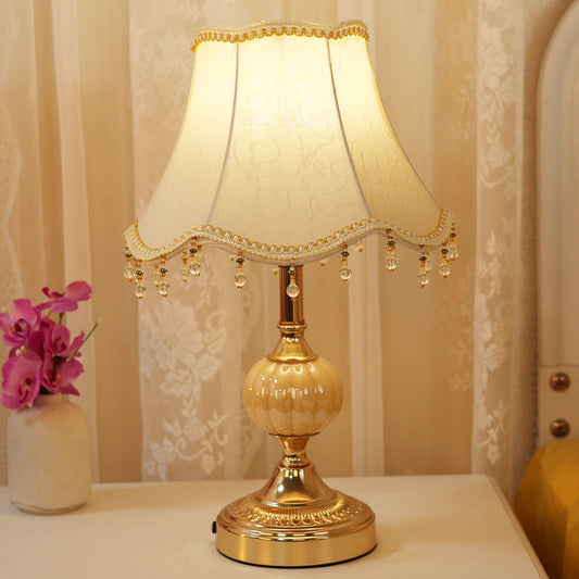 Vintage-style touch table lamp with fabric shade on wooden nightstand
