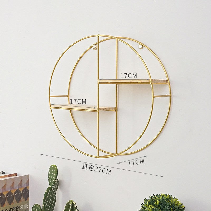 Geometric wrought iron wall shelf in gold finish on white wal
