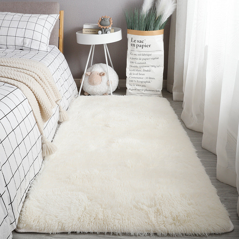 White faux silk bedroom rug on wooden floor with natural light
