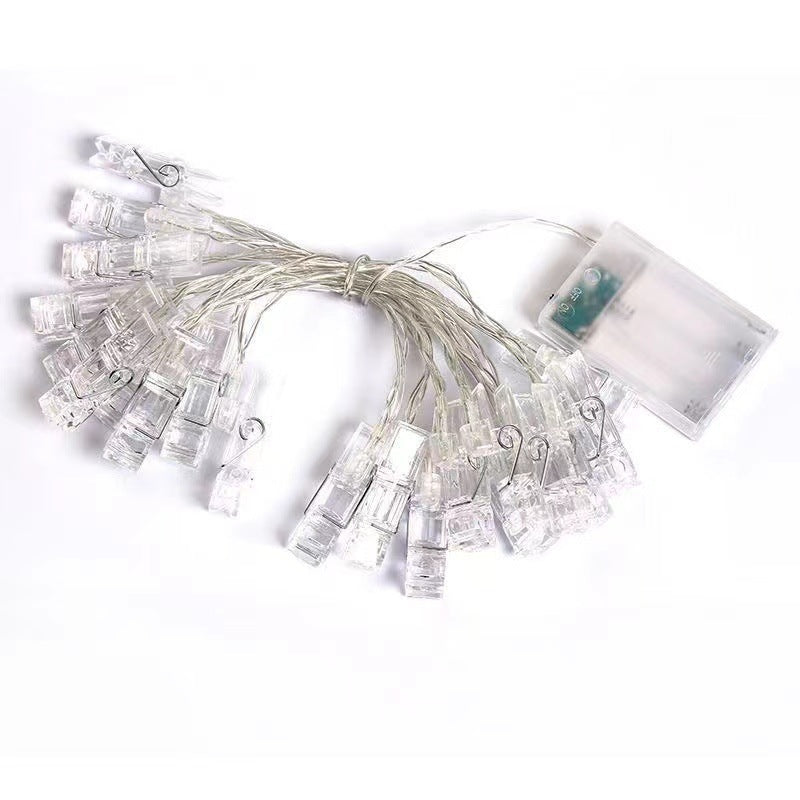 USB-powered plug with LED clip lights on white bedding
