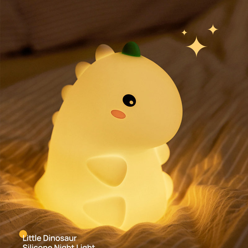 Dinosaur night light surrounded by plush toys in a kids’ corner
