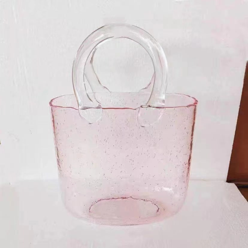 Pastel pink handbag vase on minimalist table
