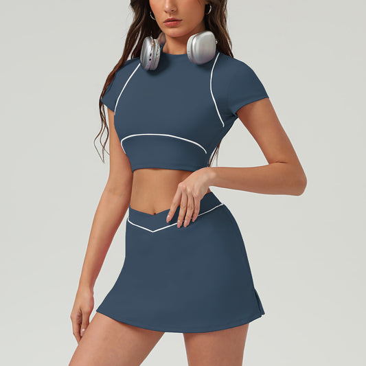Woman wearing a blue athletic outfit with white accents on a gray background