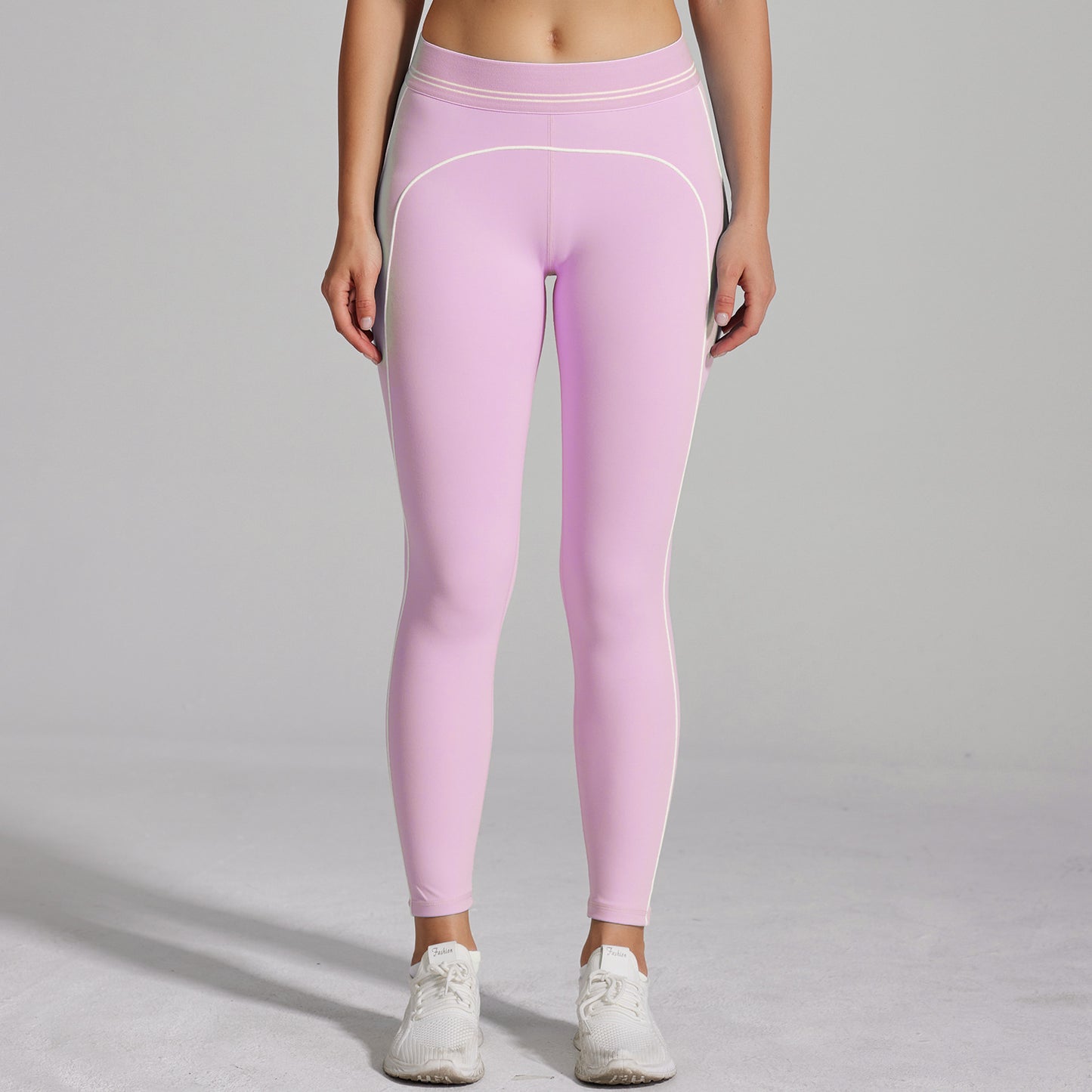 Person wearing pink leggings on a gray background