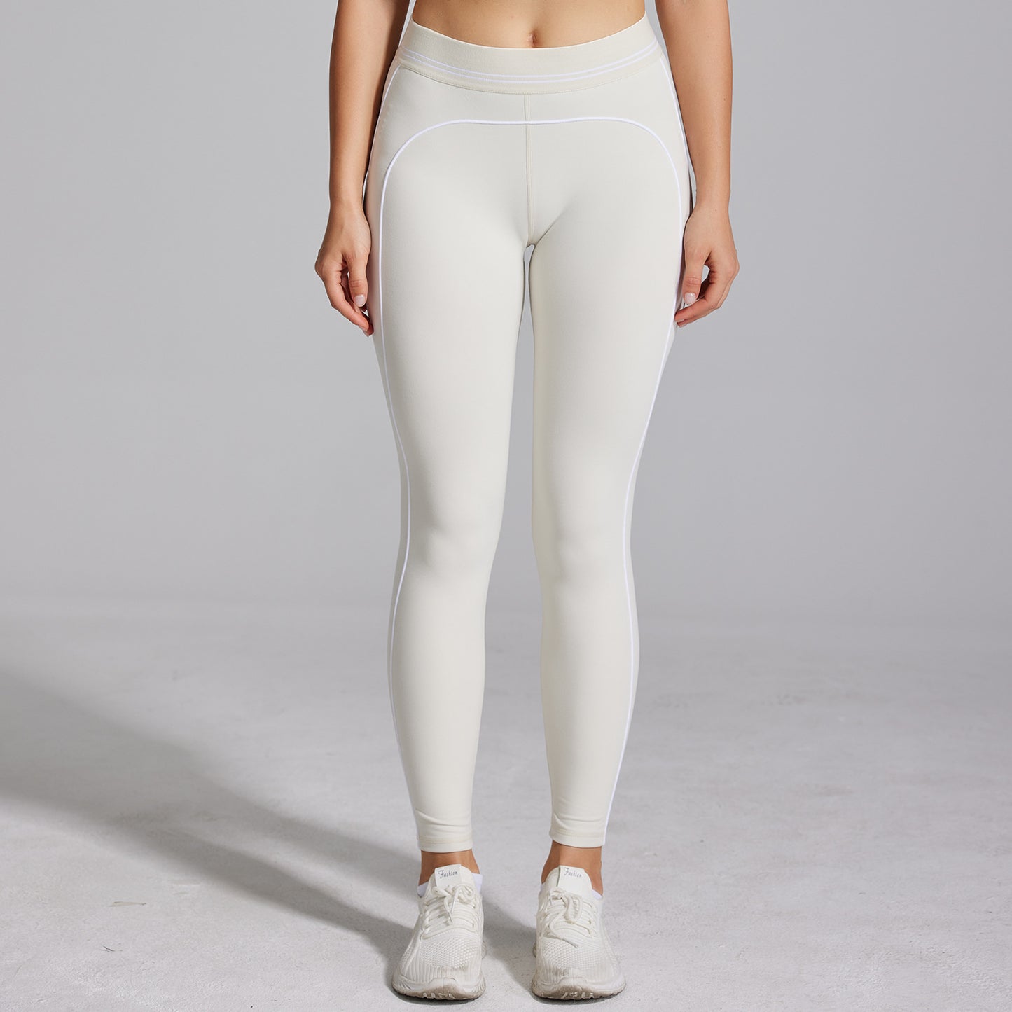 Person wearing white leggings on a plain background