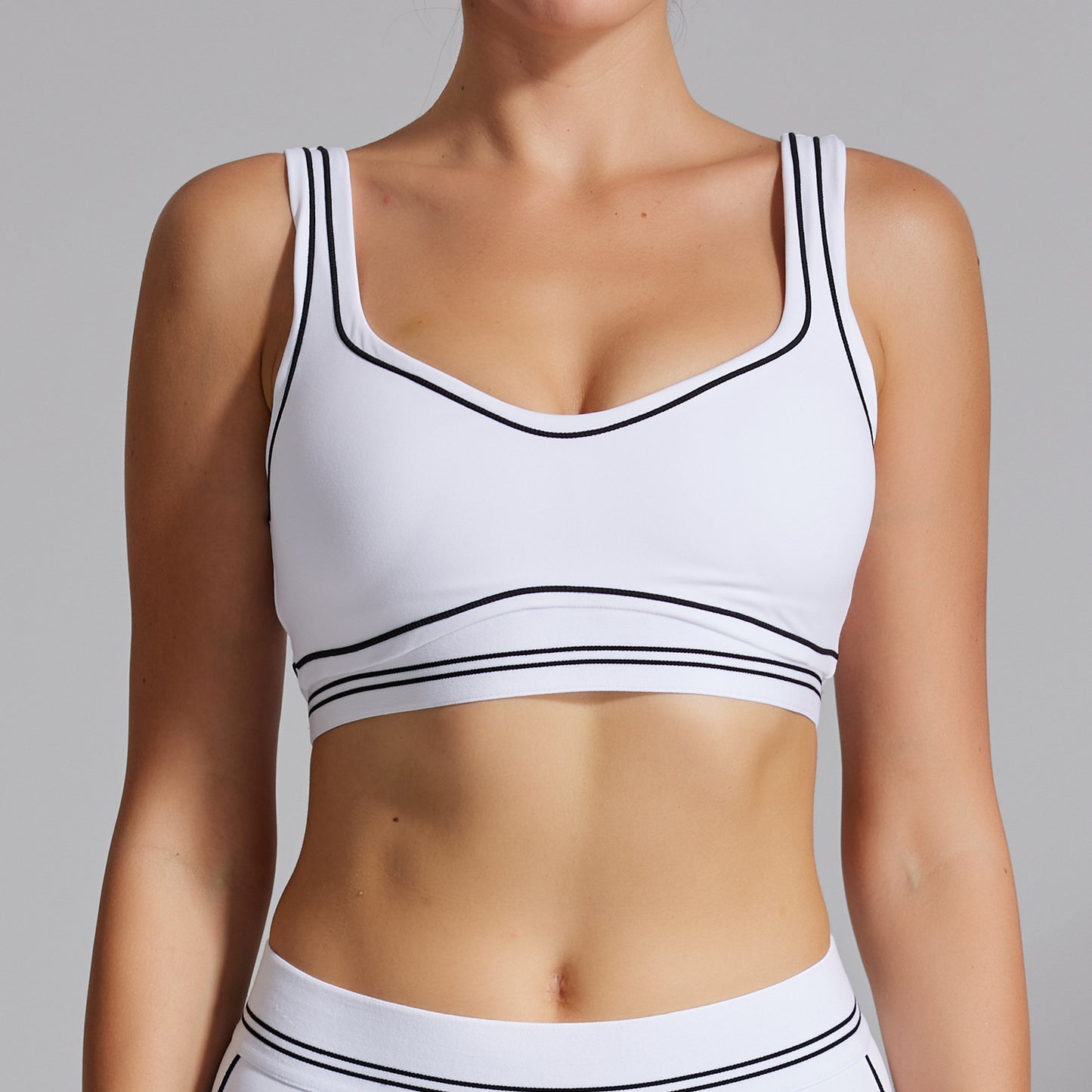 White sports bra with black accents on a gray background