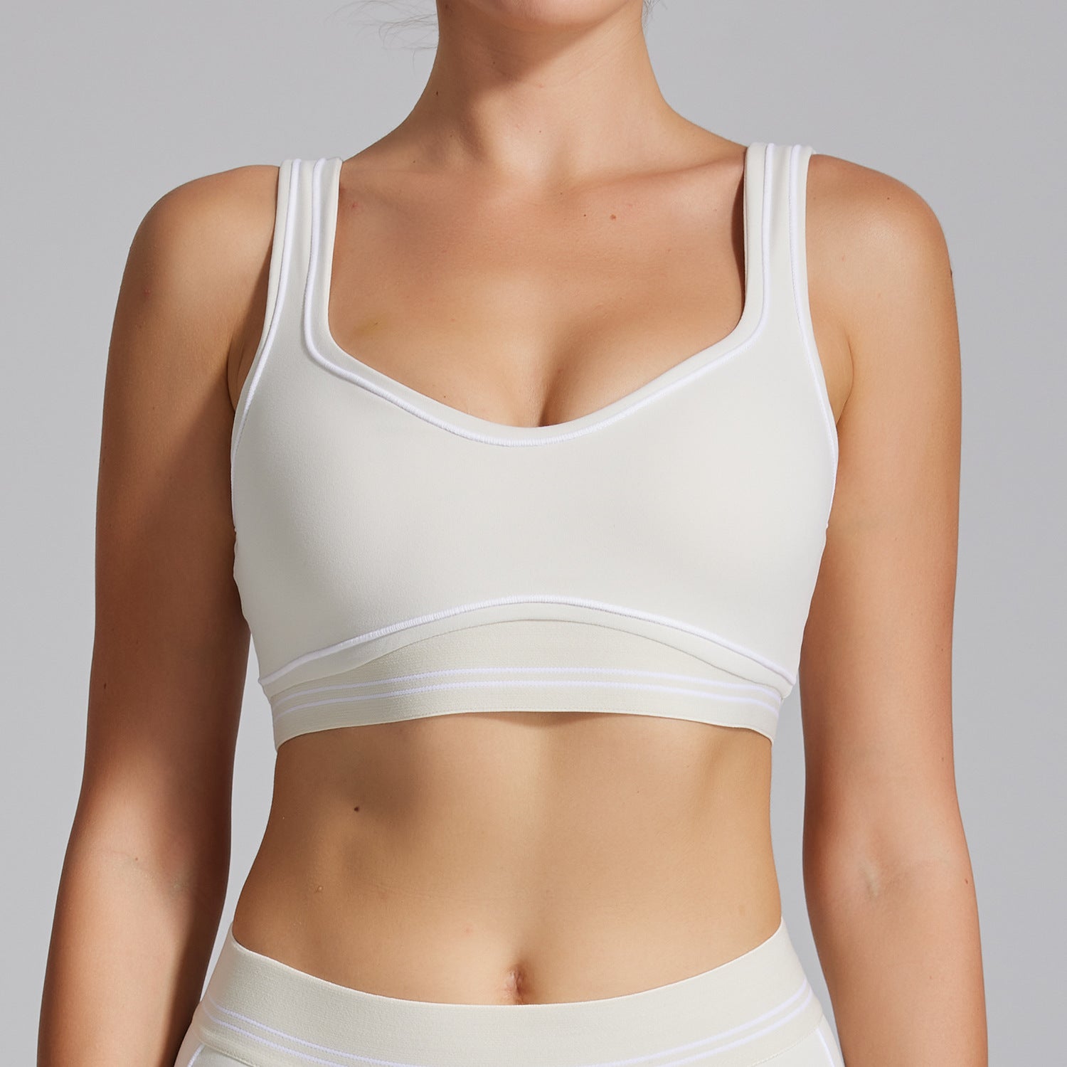 White sports bra worn by a person on a gray background