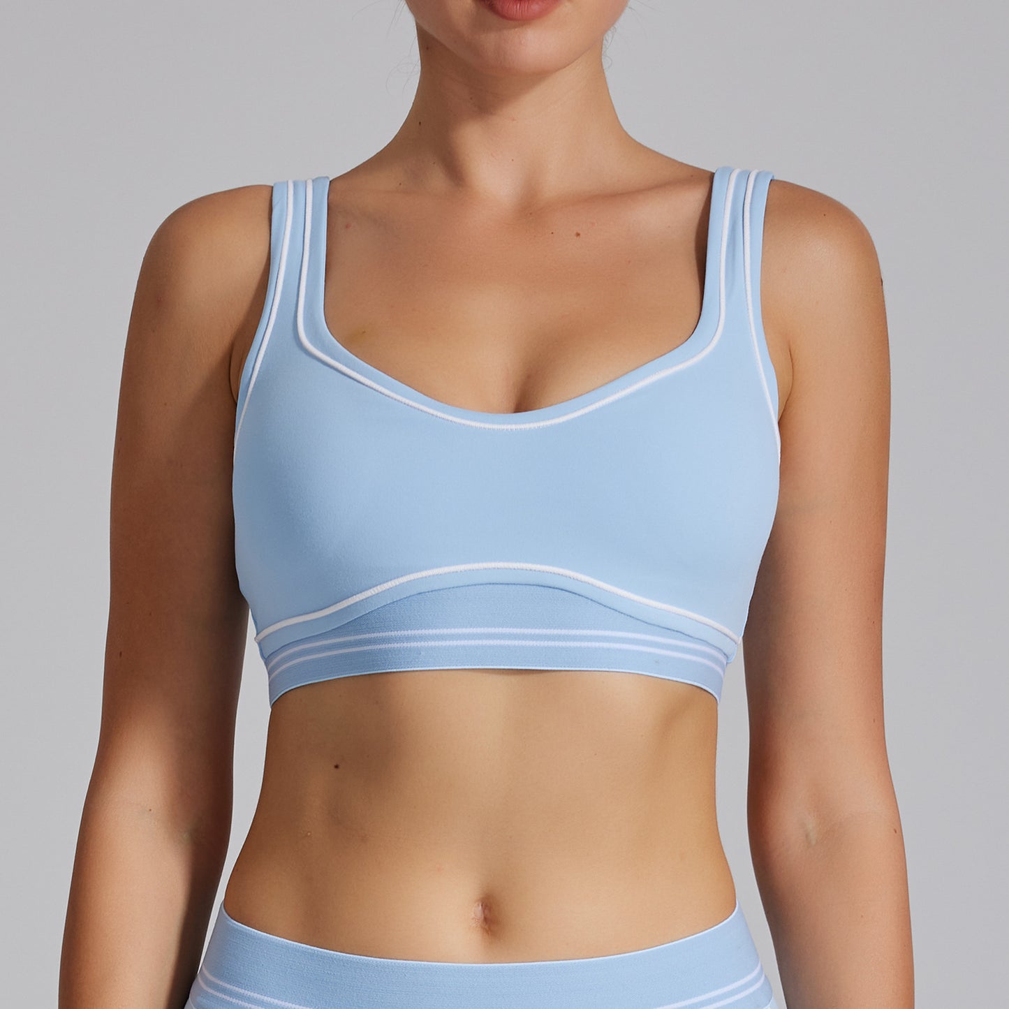 Light blue sports bra worn by a person on a gray background