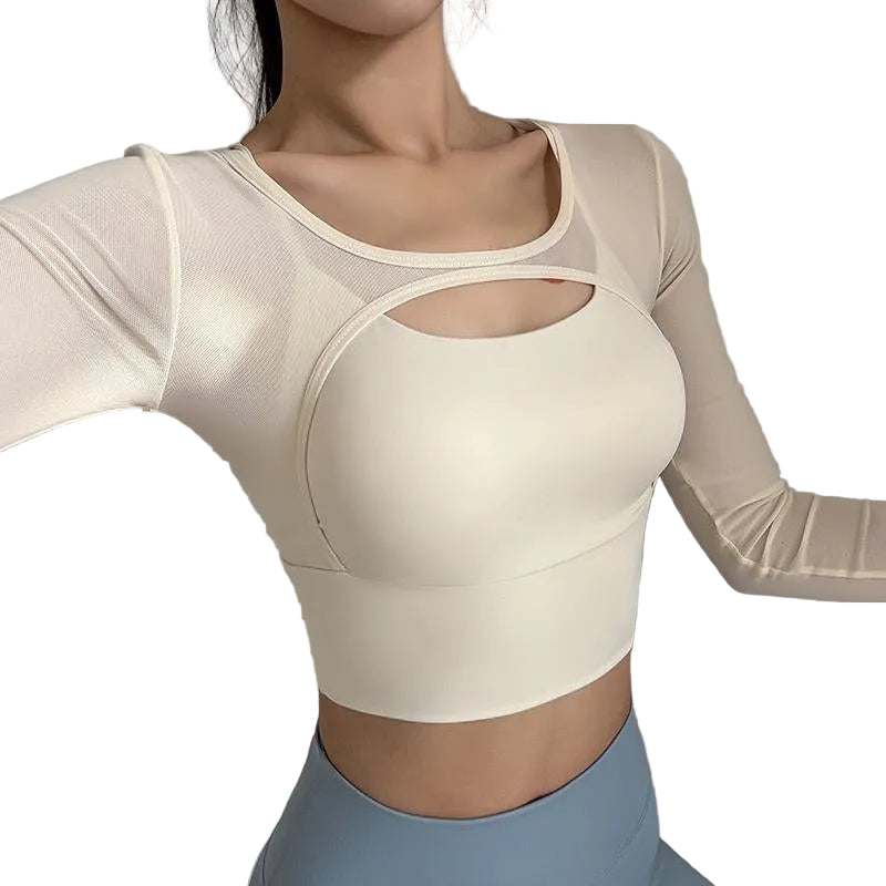 Woman wearing a beige long-sleeve sports bra with mesh panels on a gray background