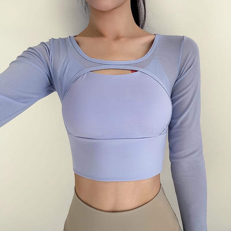 Person wearing a light purple long-sleeve athletic top and beige leggings on a plain background