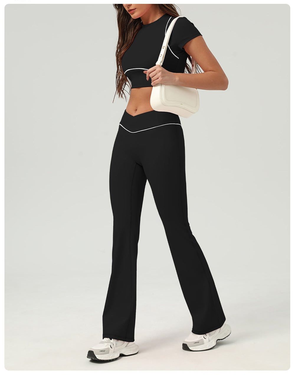 Woman wearing a black athletic outfit with a white background