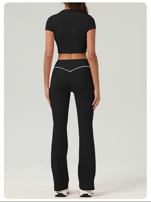 Woman wearing a black athletic outfit with a white background