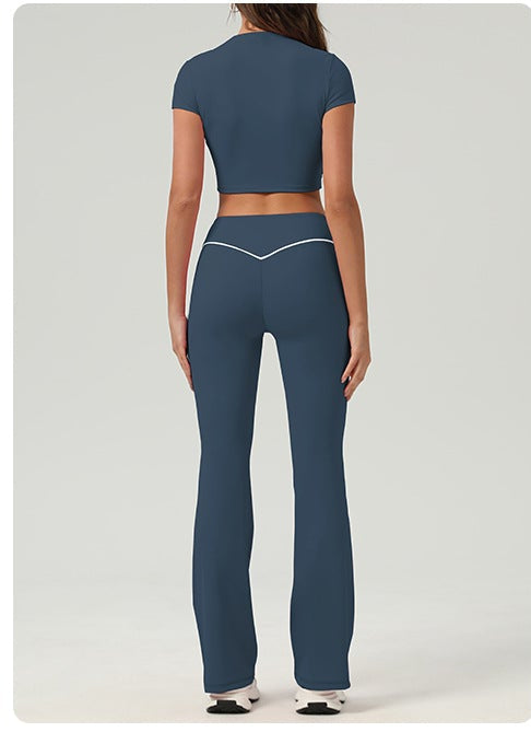 Woman wearing a blue athletic outfit with matching pants and top on a white background.