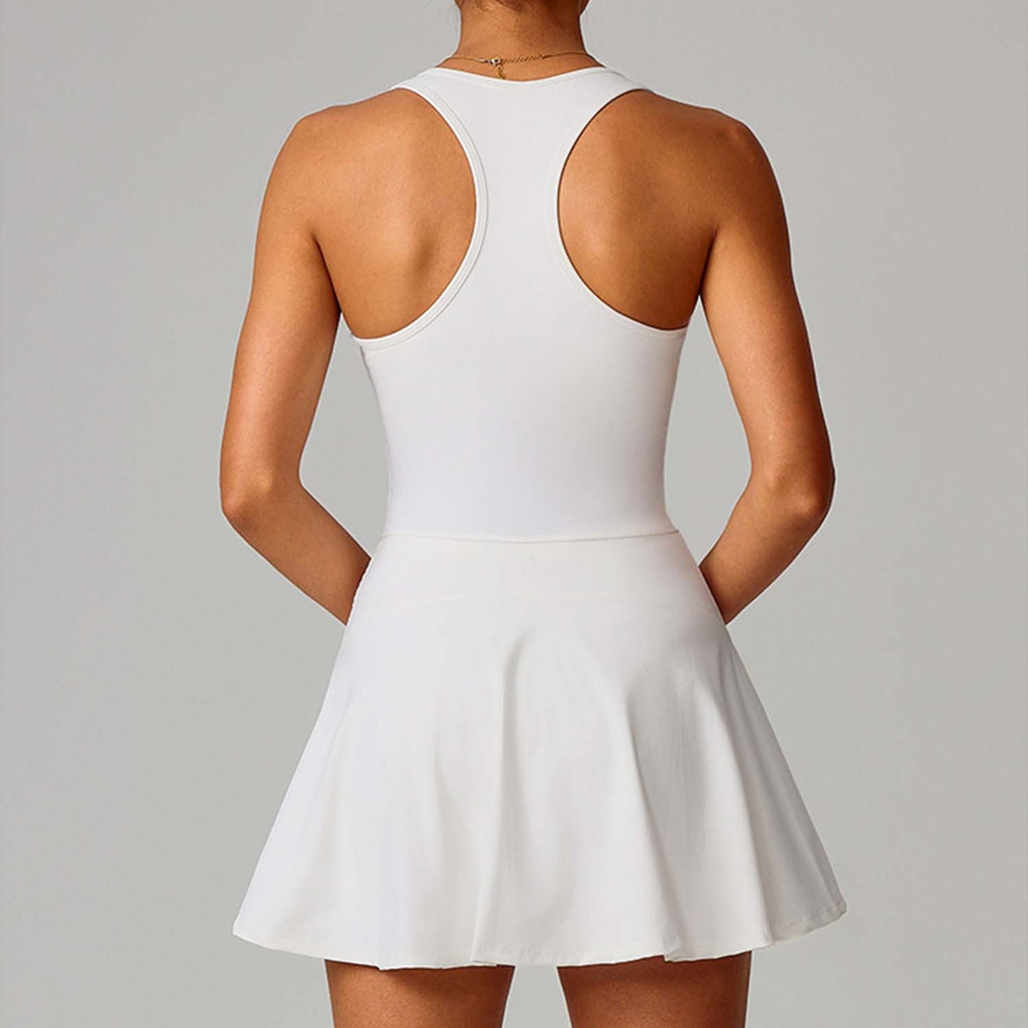 White dress with open back on a plain background