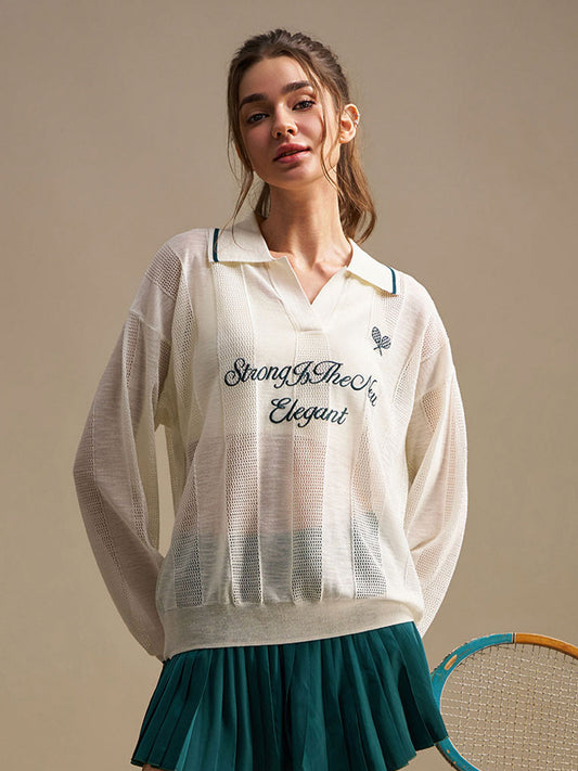 Woman wearing a white embroidered shirt with text, standing against a beige background