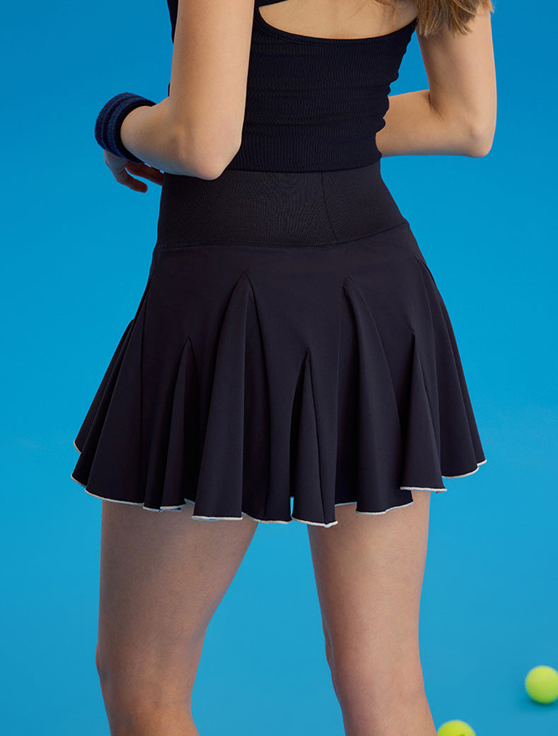 Person wearing a blue pleated skirt against a blue background