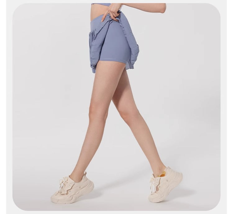 Person wearing light blue shorts and white sneakers on a white background