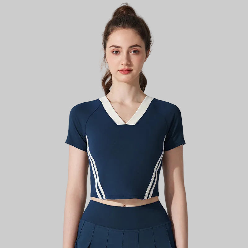 Woman wearing a navy blue outfit with white accents on a gray background