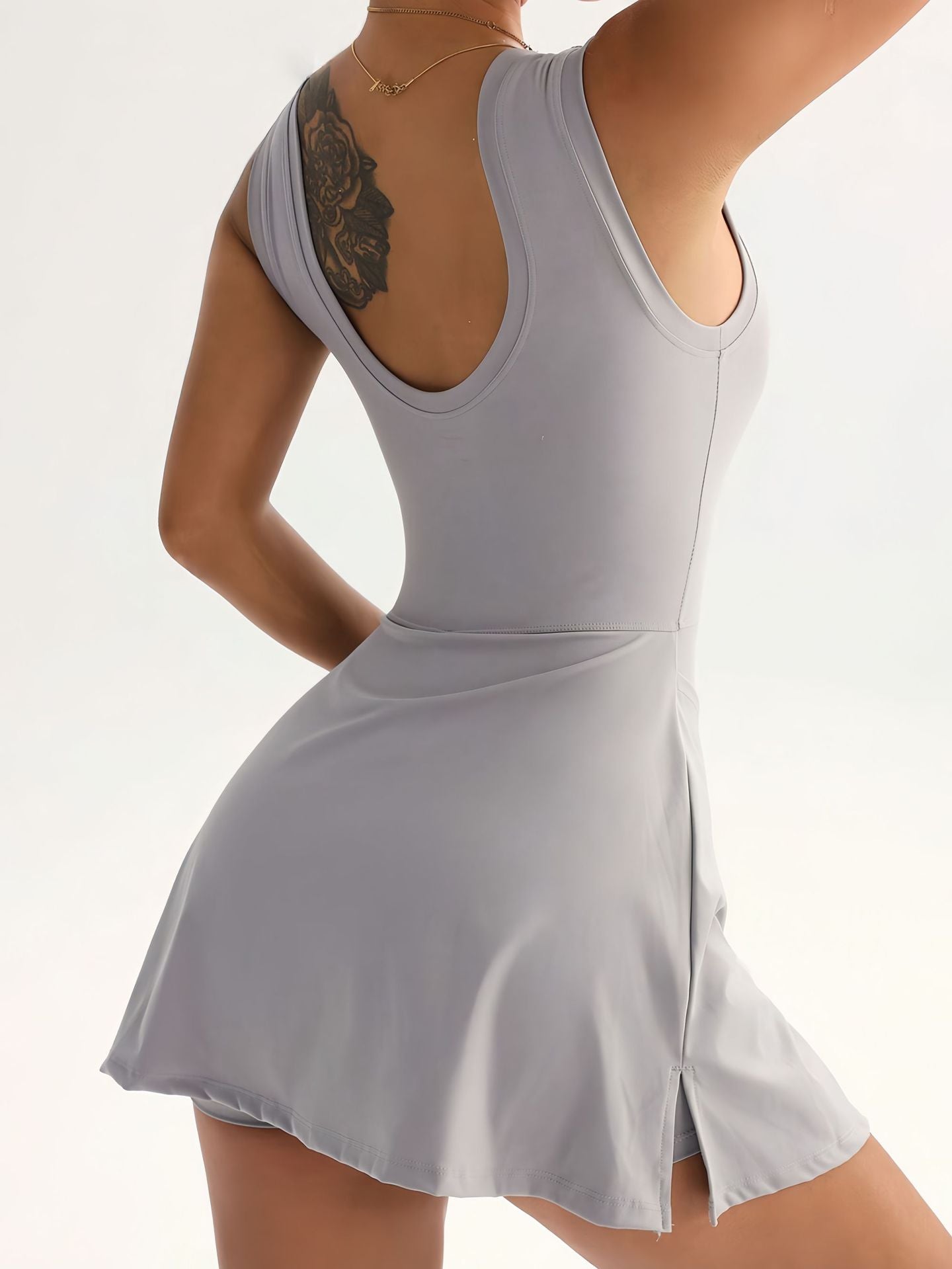 Gray dress with open back worn by a person on a white background