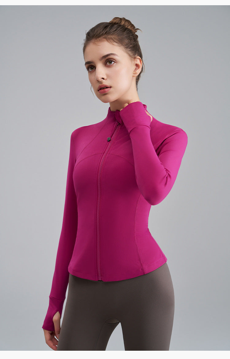 Woman wearing a bright pink long-sleeve top against a gray background