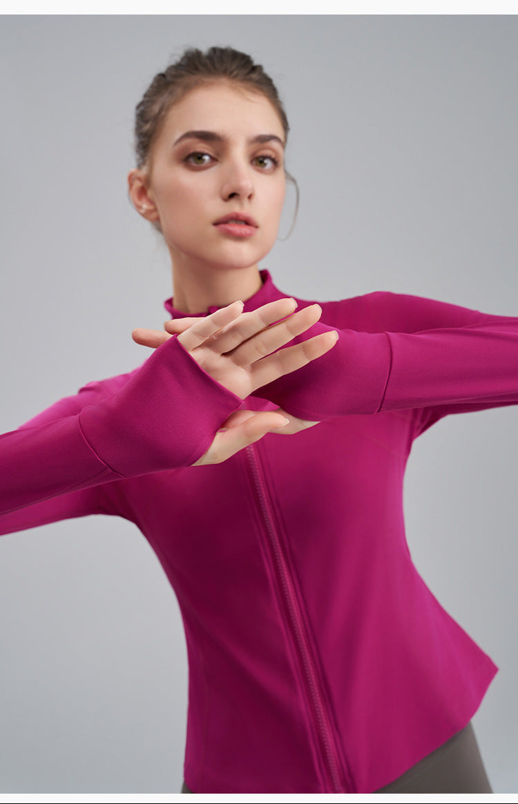 Woman wearing a pink long-sleeve top against a gray background